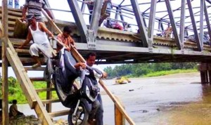 Sepeda Motor Diangkat Naik Tangga di Jembatan Naga Juang